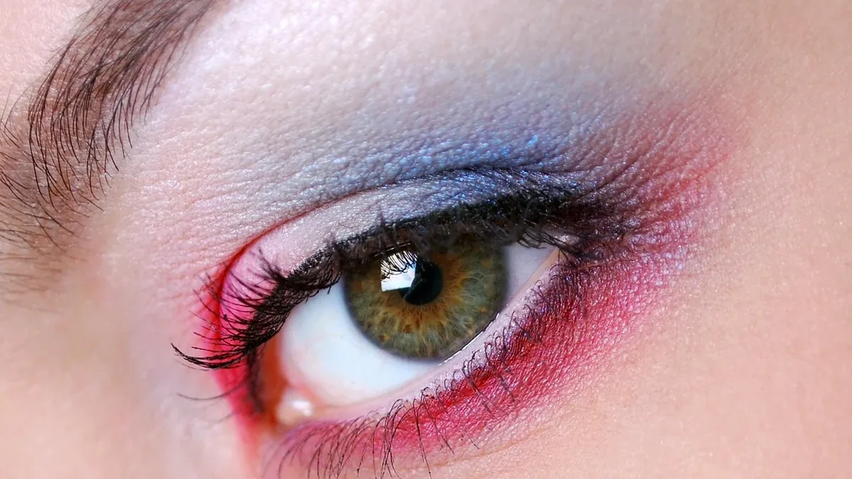 A close-up of a woman's eye with a colorful eyeshadow look.